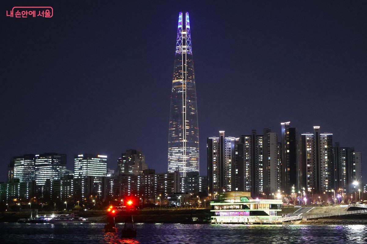 잠실선착장 배경, 어둠 속에서 화려한 조명으로 빛나는 선착장 주변 빌딩 마천루가 압도적인 존재감을 뽐낸다. ⓒ이봉덕