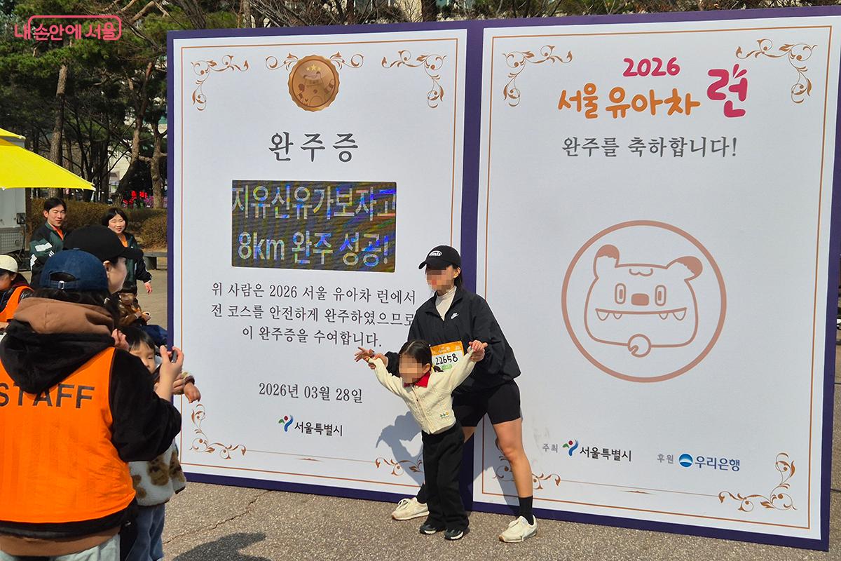 완주 기념 포토존 앞은 완주 메달을 목에 걸고 포즈를 취하는 가족들로 웃음꽃이 피어났다.