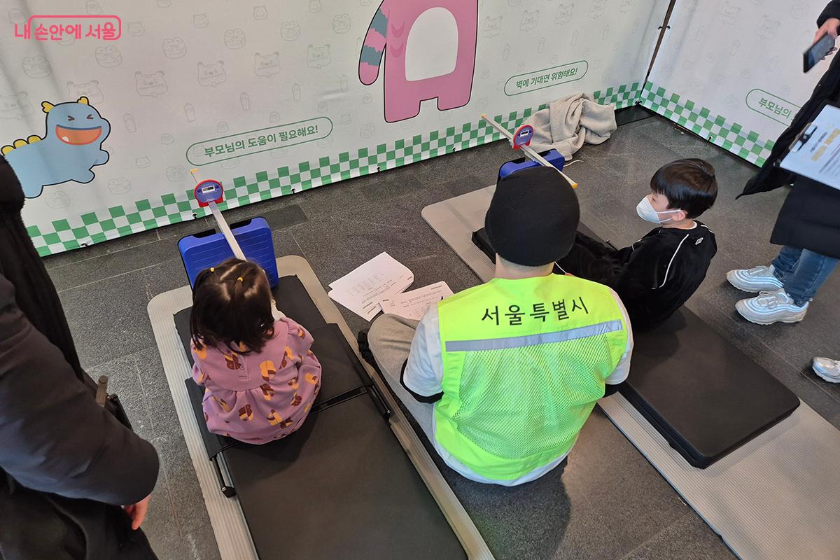어린이들이 전문가의 도움을 받아 유연성을 측정하고 있다. ©백승훈