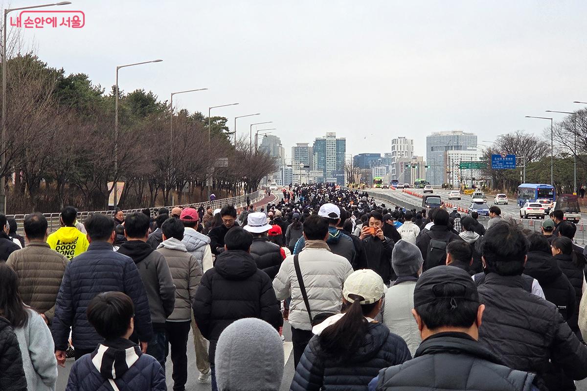 자동차 대신 시민들의 활기찬 발걸음으로 가득 찬 주말 아침의 여의도 도로 풍경 &copy;이다현