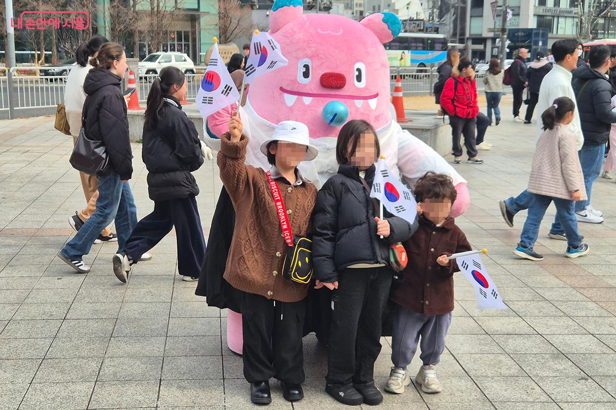 서울특별시의 상징 캐릭터인 '해치'와 함께 기념촬영을 하고 있는 어린이들
