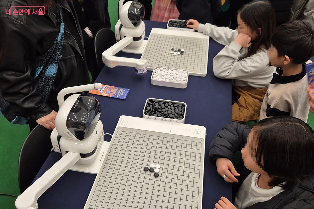센스타임(SenseTime)의 AI 바둑 로봇인 센스로봇 고(SenseRobot Go)와 대국에 열중하고 있는 참가자들