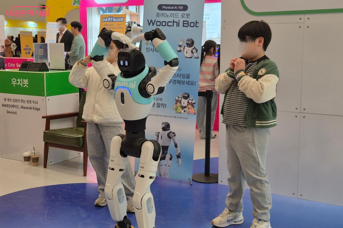 휴머노이드 로봇이 어린이들과 사진 포즈를 취하고 있다. ⓒ마가은
