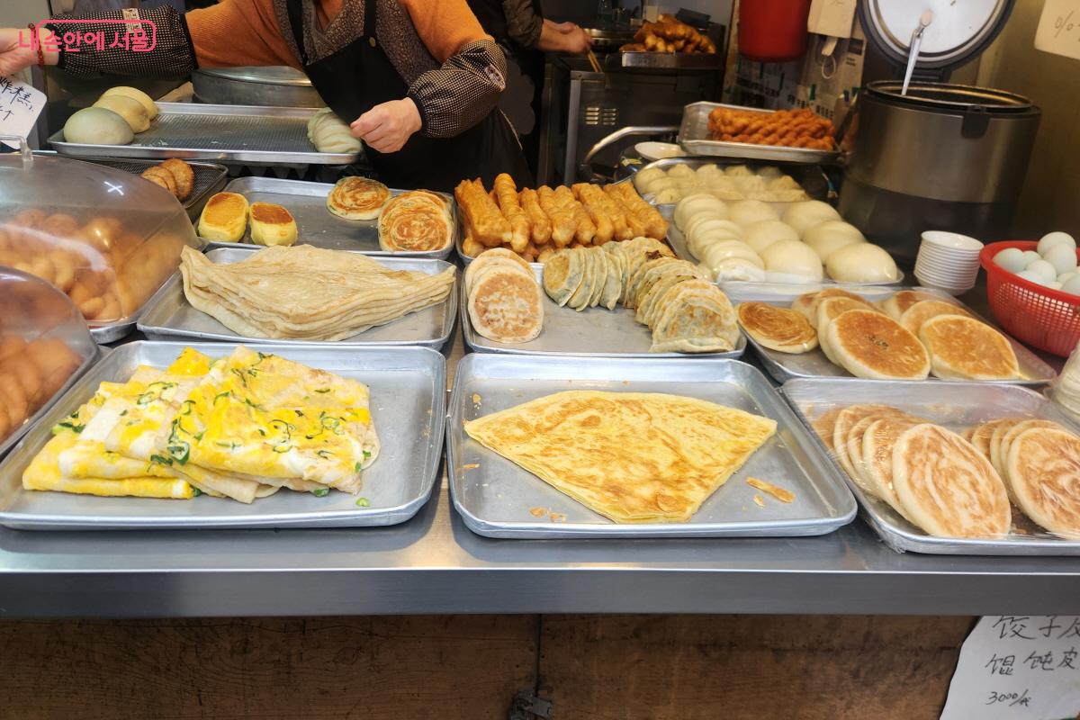 남구로시장 한 점포에 호떡 모양과 찐빵 모양의 빵류, 계란부침 형태의 중국식 음식이 진열돼 있다. 둥근 모양의 간식들이 판매를 위해 가지런히 놓여 있다.