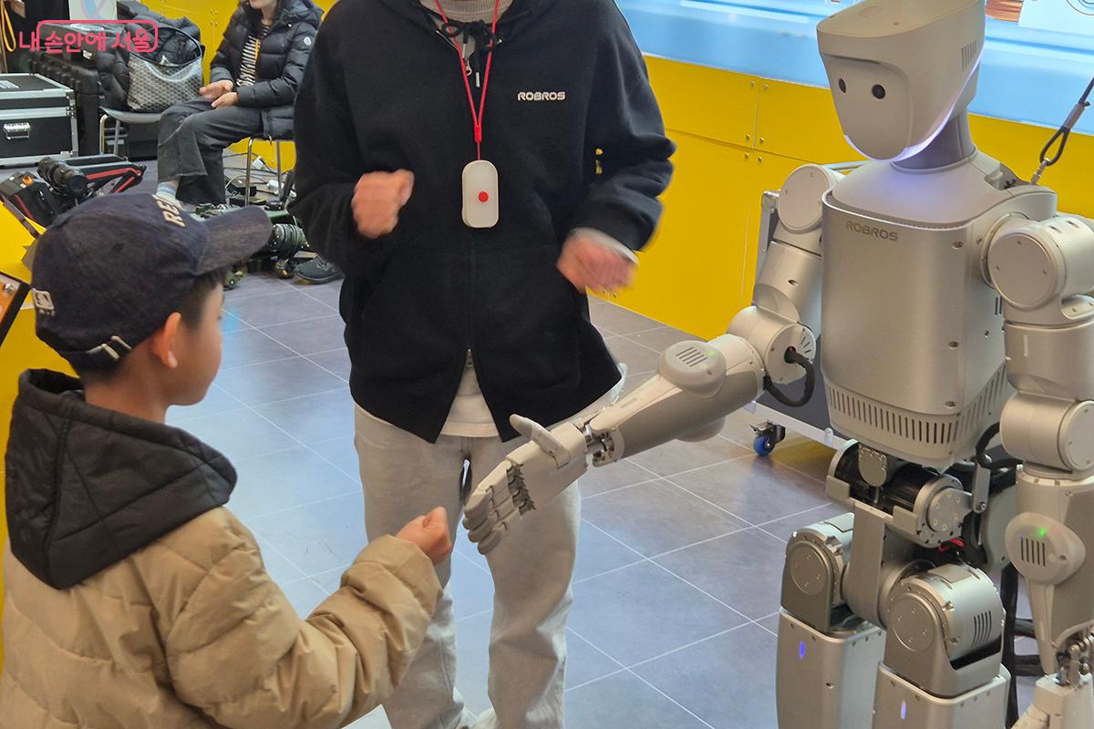로봇과 관람객의 악수는 인간과 기술이 나누는 첫 번째 '악수'처럼 느껴진다.