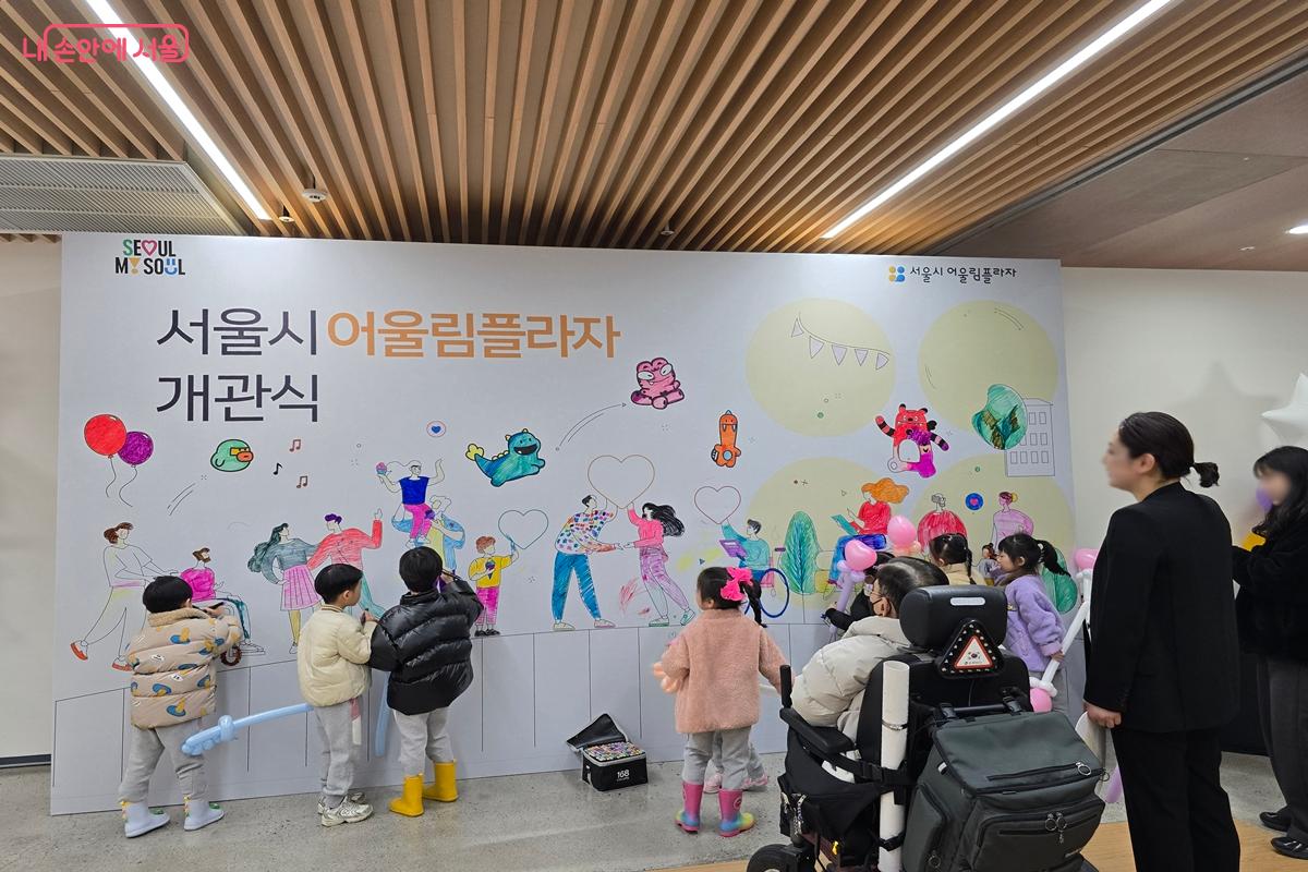 배리어프리 컬러링월에 색칠을 하는 아이들과 지켜보는 가족들 &copy;강사랑