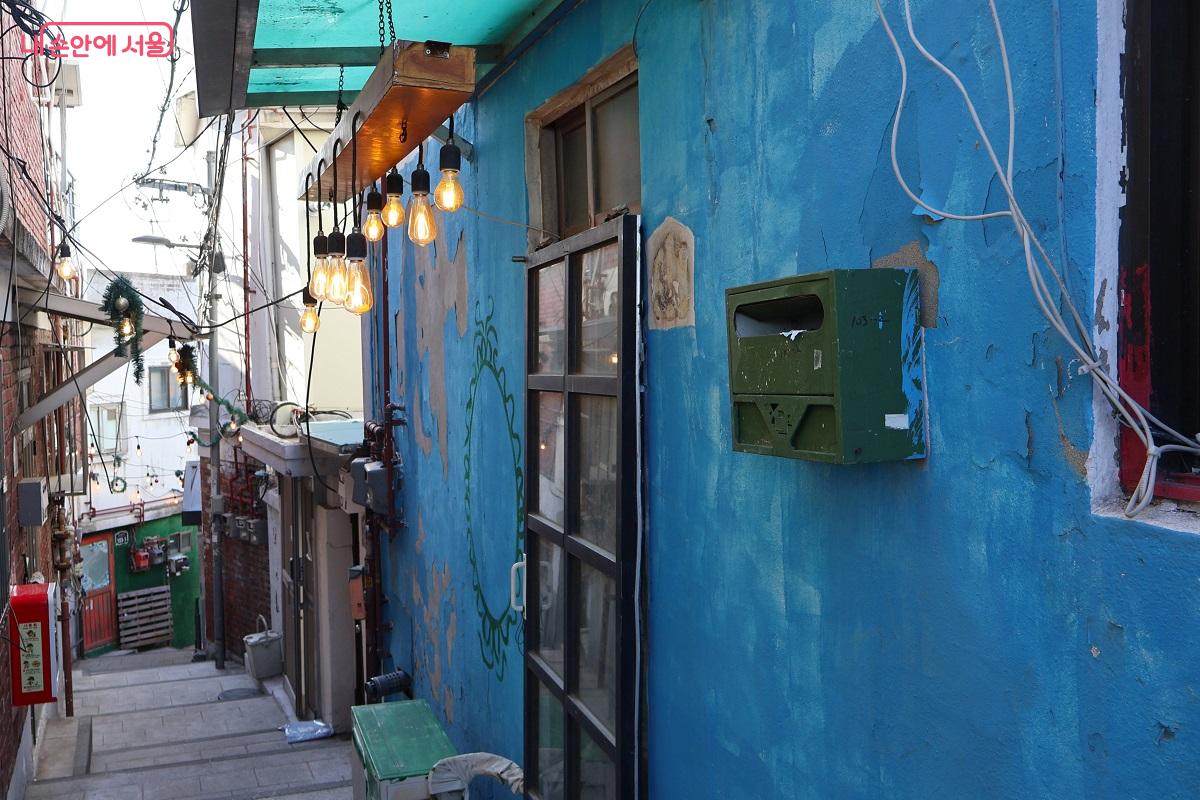푸른 벽면과 은은한 전구 조명이 조화를 이루어 낡은 골목에 낭만을 더한다. &copy;이봉덕