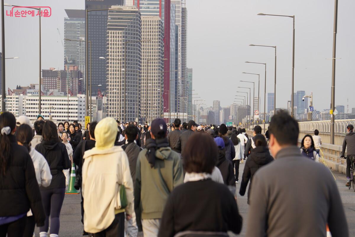 마포대교 위 반환점을 향해 나아가고 있는 사람들의 모습이다.