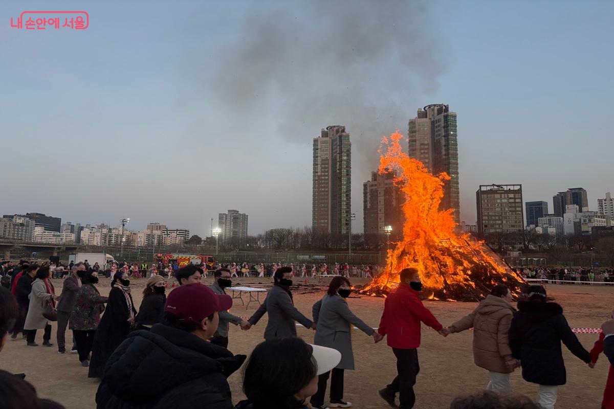 시민들이 달집을 에워싸며 지신밟기와 강강술래를 즐기고 있다. ⓒ조현영