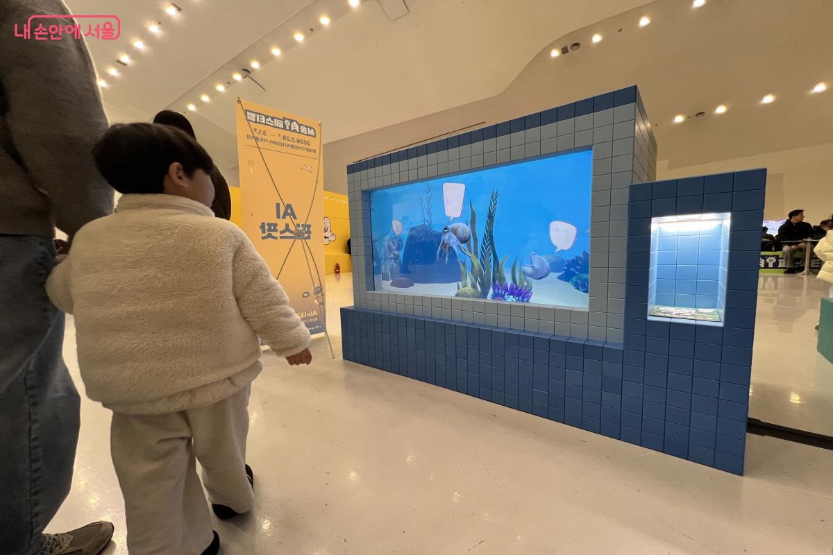 종이에 색칠을 해서 기기에 올려두면 영상에 반영되는 AI기기를 아이가 바라보고 있다. ⓒ박지영