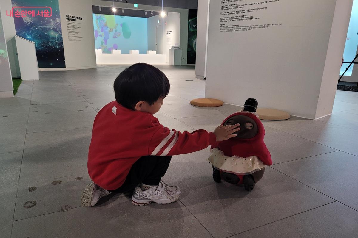 서울로봇인공지능과학관 전시 공간에서 어린이가 로봇과 교감하고 있다. &copy;조연