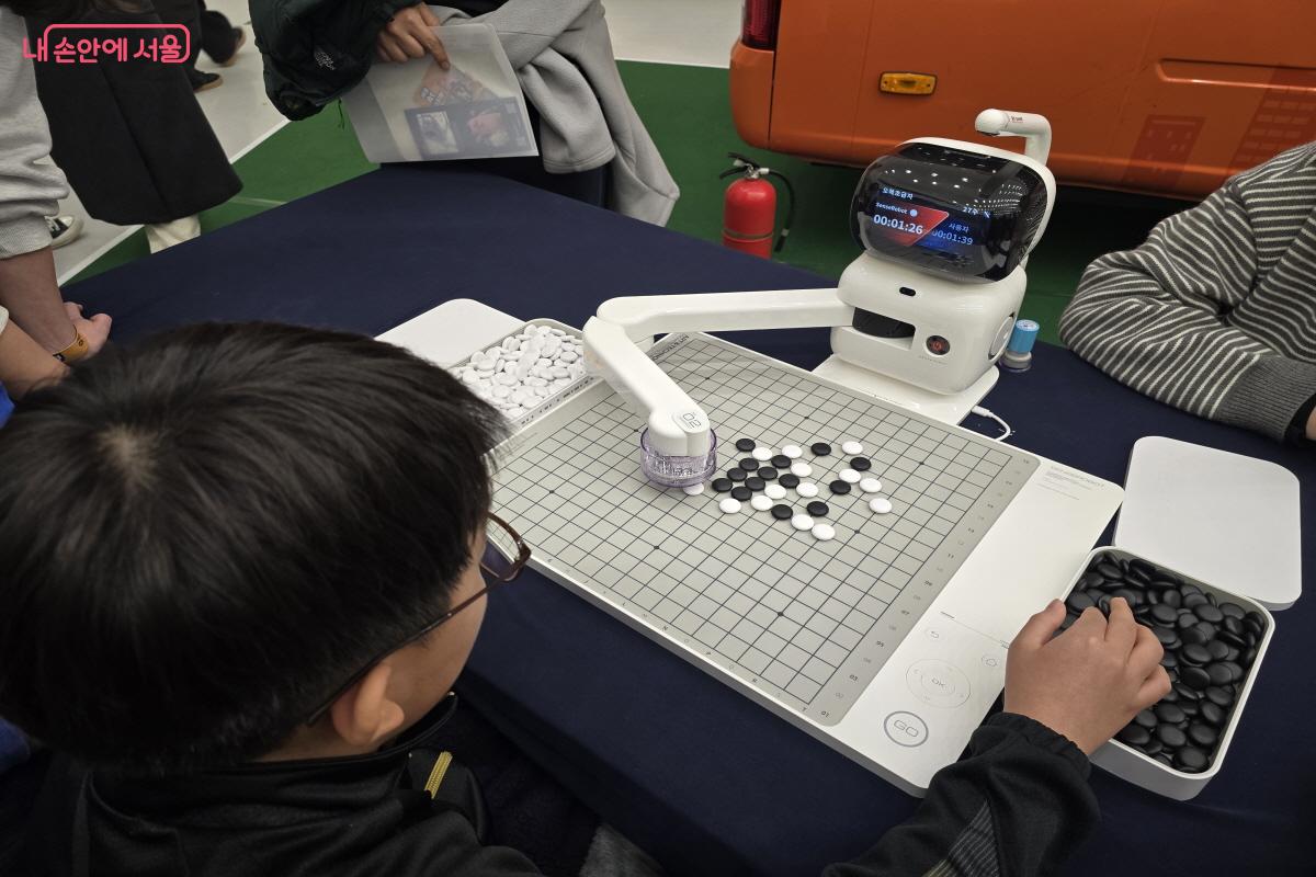 로봇과 오몫을 두고 있는 아이.