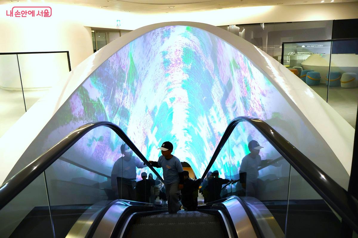미디어 아트가 펼쳐지는 에스컬레이터를 타고 미래 과학의 세계로 들어가는 어린이들 &copy;김대진