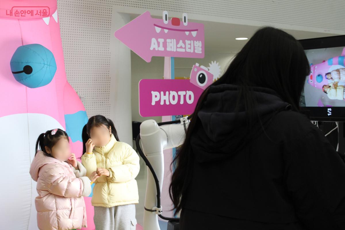'AI기술체험존'에서 해치와 함께 사진을 찍는 어린이 관람객