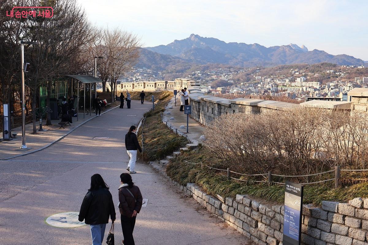 성곽 너머로 병풍처럼 펼쳐진 북한산과 성곽의 곡선이 어우러져 있다. &copy;이봉덕