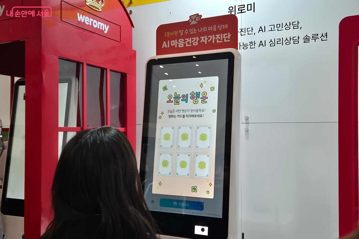 AI 마음건강 자가진단 키오스크를 활용해 체험자의 마음 상태를 진단하고 있다. 화면에는 '오늘의 행운'이라는 문구가 떠있다. ⓒ마가은