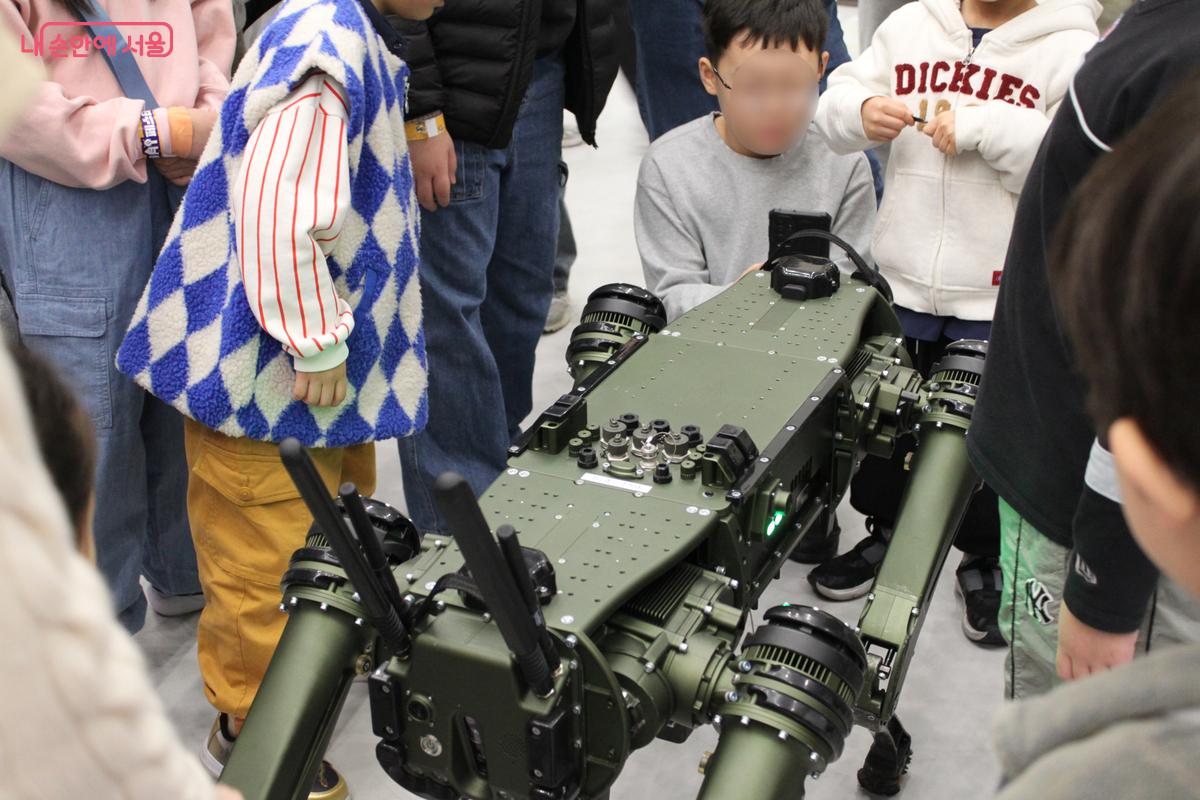 '휴머노이드로봇존' 뒷편에서 어린이 관람객과 소통하고 있는 사족보행 로봇