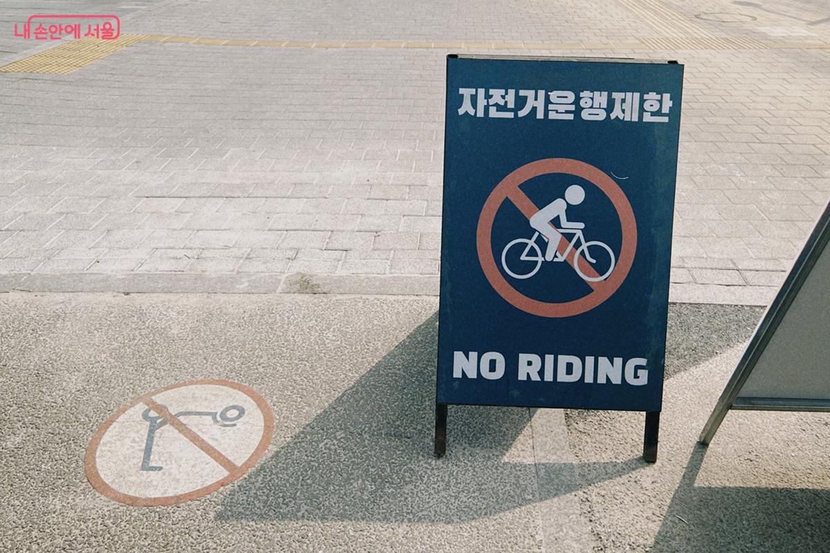 출입구에 자전거 운행 제한 입간판이 설치되어 있다. ⓒ김아름