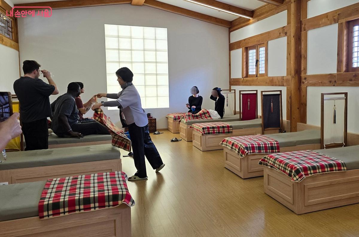 발열 안대와 기계식 온열 안마 매트 체험을 마친 관광객들 &copy;조성희