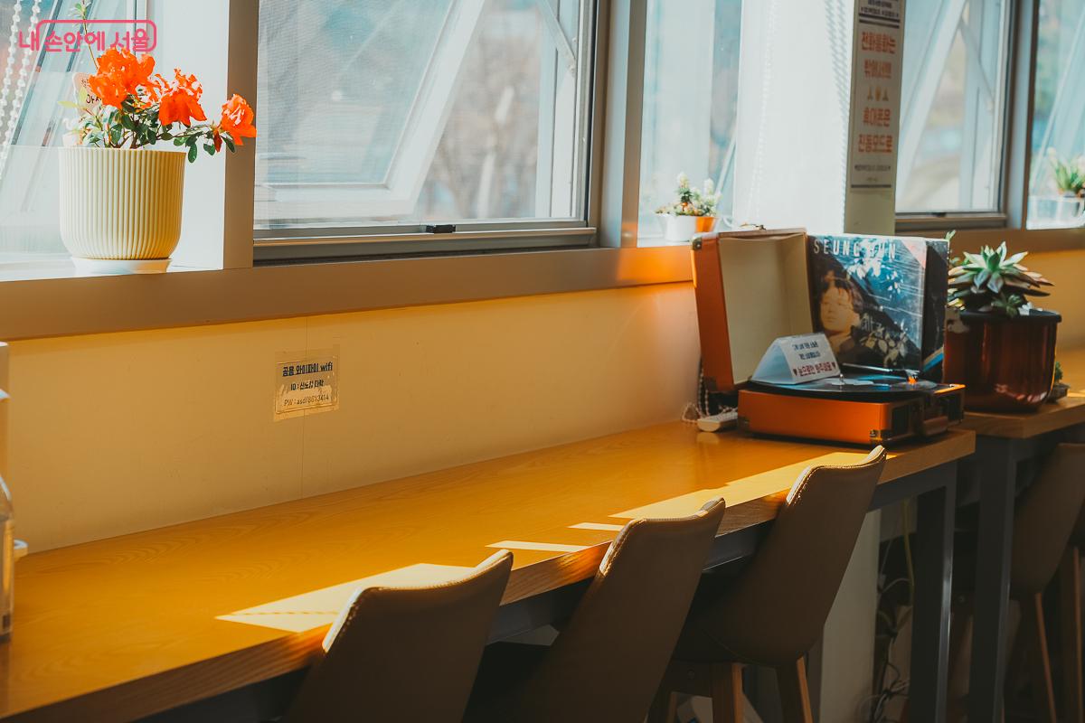 창가 바 테이블 위로 햇살이 비치고 빈티지 턴테이블이 놓인 모습 &copy;김성무