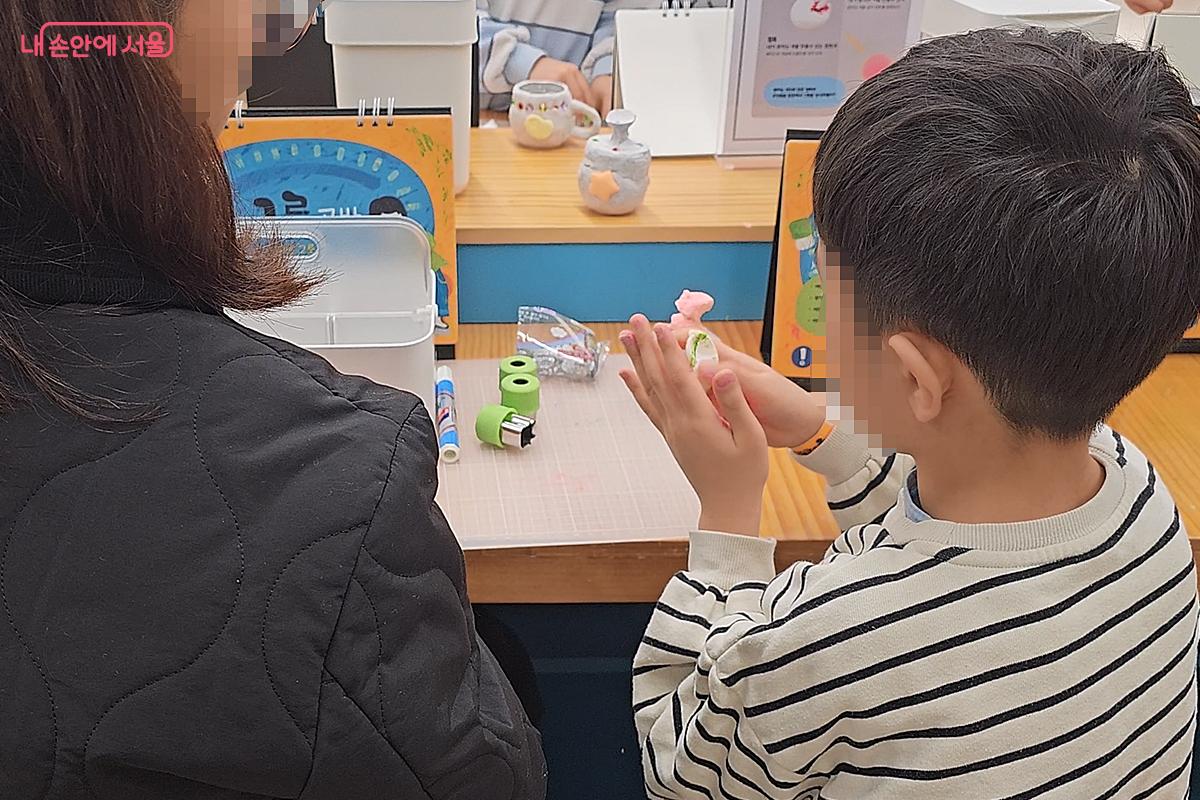 그릇공방에서 고사리 손으로 병에 흙을 붙여 컵을 만드는 어린이 &copy;오도연