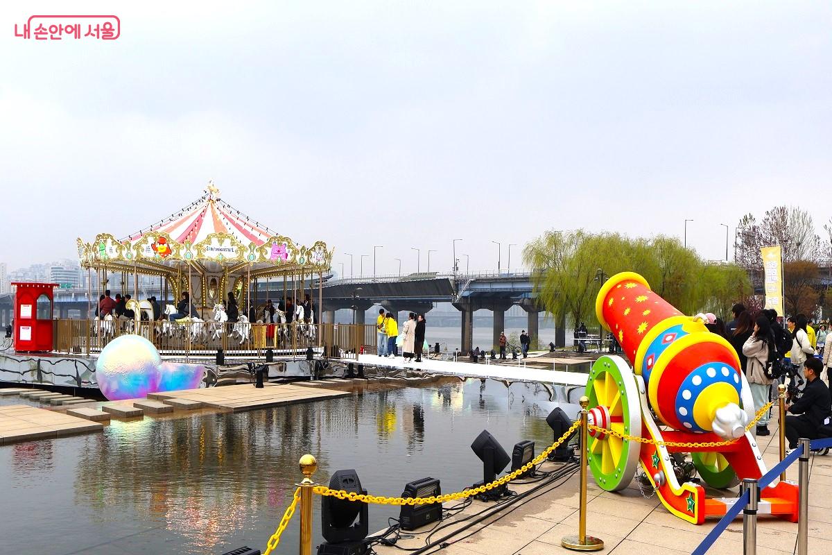 수변 위에서 돌아가는 한강 회전목마와 축제장의 활기찬 풍경 ⓒ이봉덕