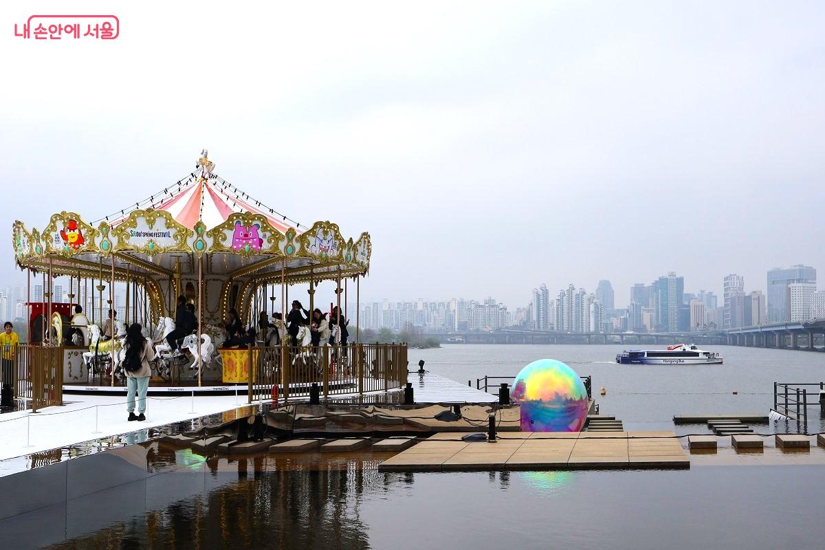 한강과 한강버스를 배경으로 물 위에서 돌아가는 환상적인 '한강회전목마' ⓒ이봉덕