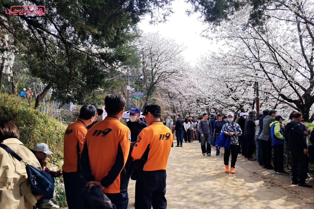 인파가 몰리는 벚꽃길에 배치되어 만약의 사고에 대비하는 소방대원들 ©장형진