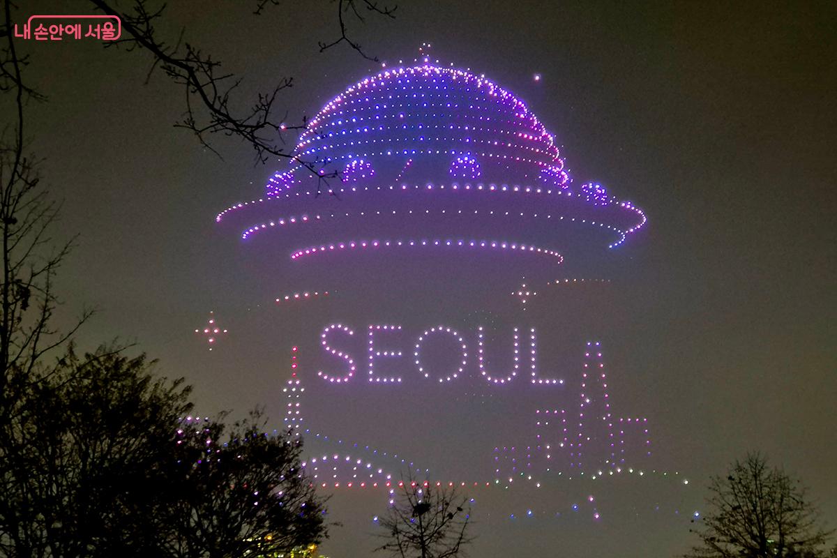 수백 대의 드론으로 만든 '서울(SEOUL)'이라는 글자가 선명한 우주선이 서울 하늘 위로 모습을 드러낸다. &copy;이혜숙