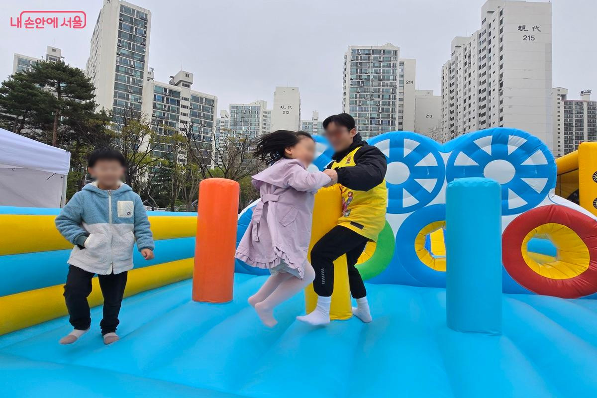 에어바운스에서 안전요원이 어린이의 손을 잡고 안전하게 지도하고 있다. ⓒ김은주
