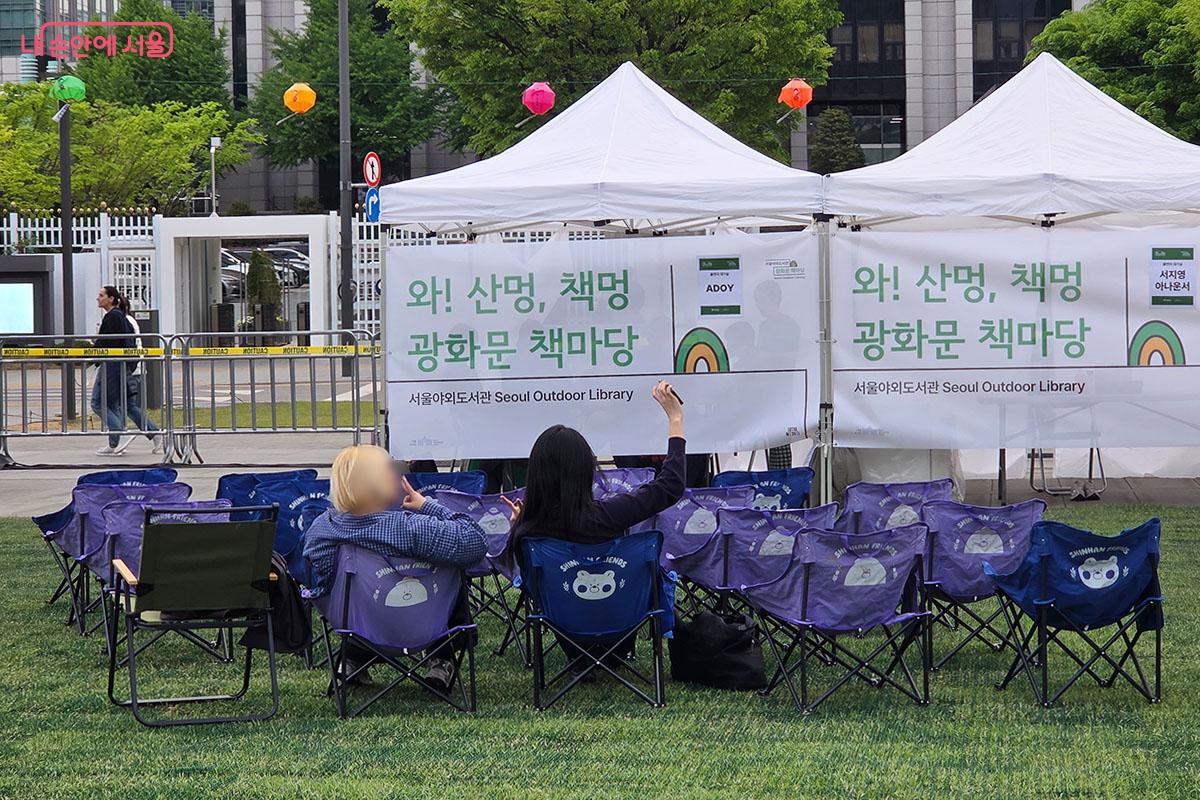 &lsquo;와! 산멍, 책멍&rsquo; 문구가 적힌 텐트 아래 책마당을 만끽하는 시민들 &copy;이다현