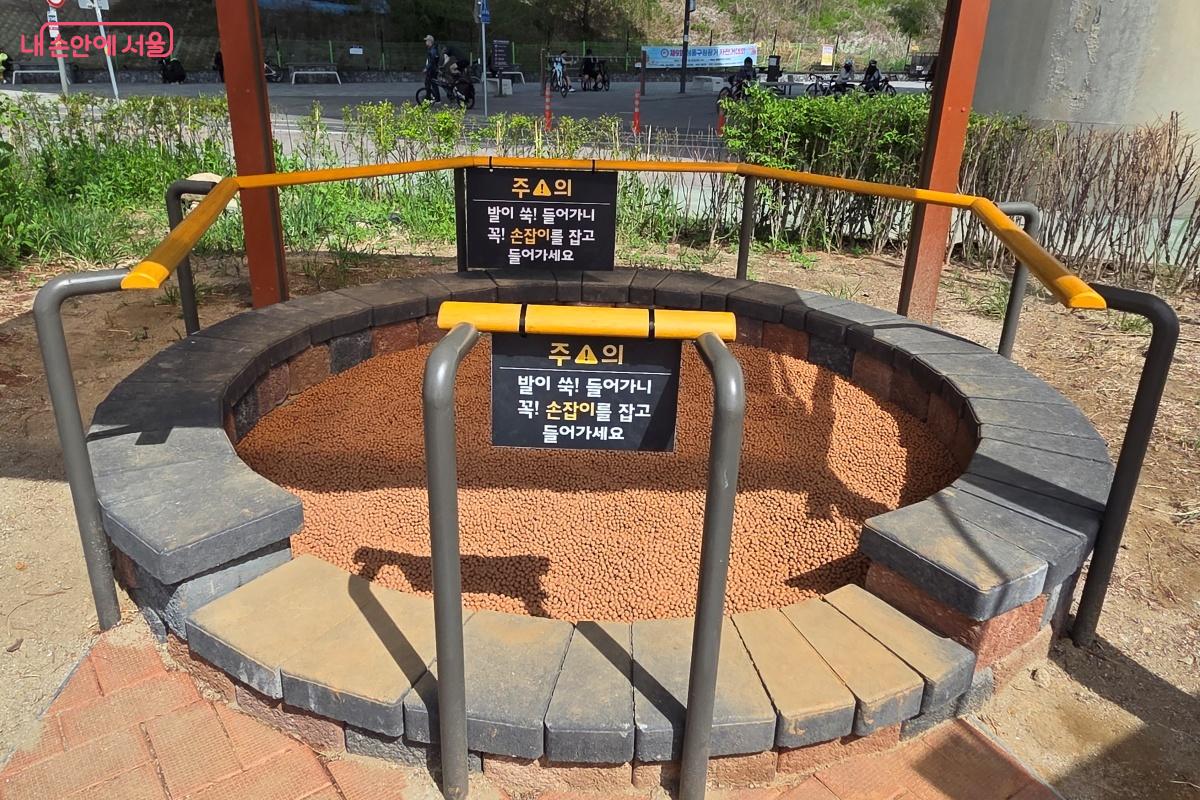 황토볼장은 발이 쑥 들어갈 수 있으니 손잡이를 잡고 이용해야 한다. &copy;김미선