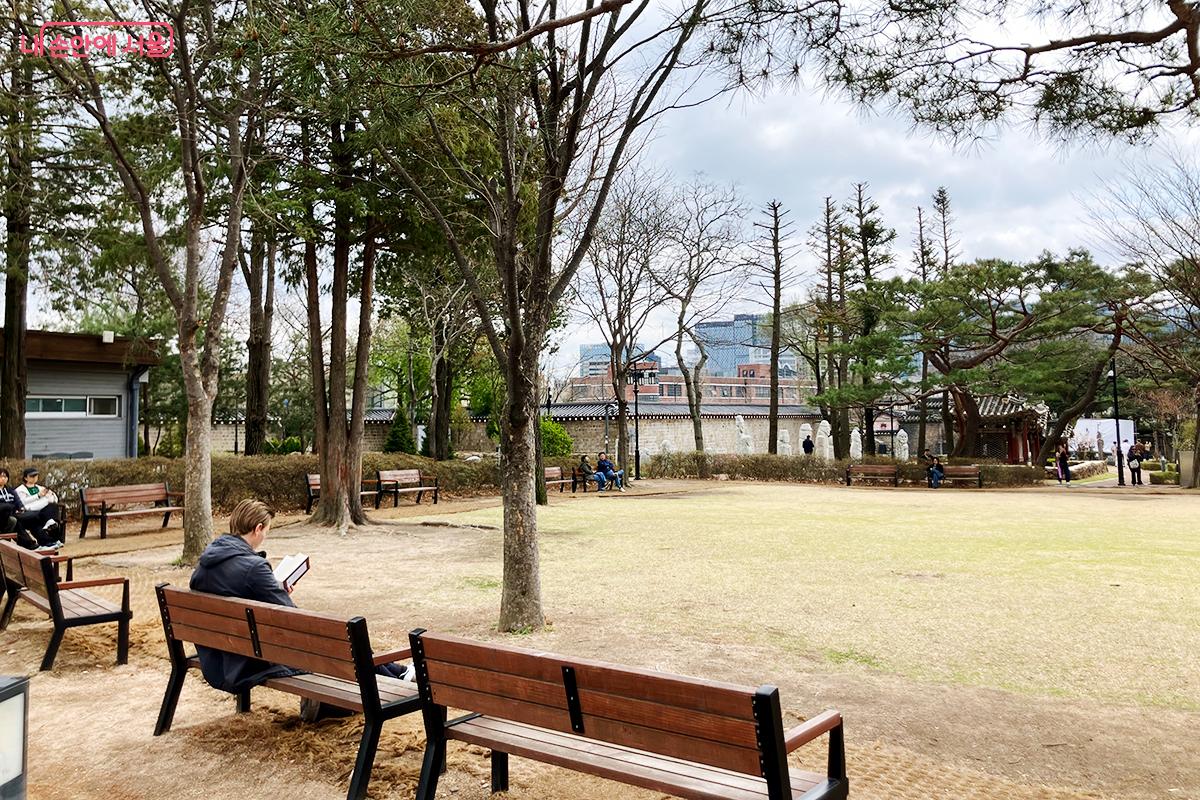 도심 속 야외 정원 벤치에서 즐기는 여유로운 독서 시간 ©이란