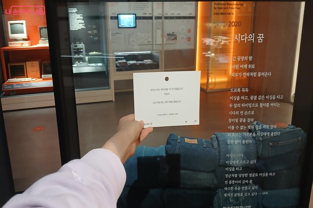 미싱사인 자신에 대한 이야기를 담은 엽서를 들고 사진을 찍었다. ©유지민