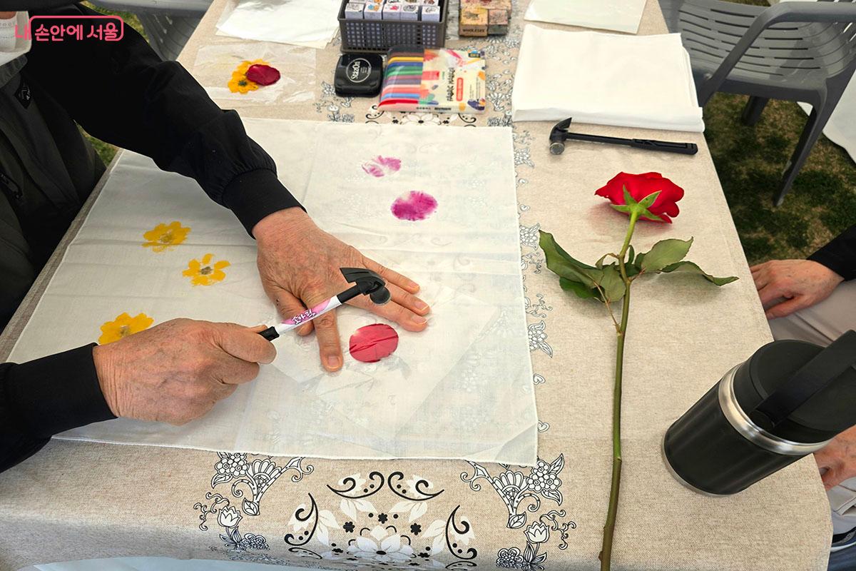 망치로 꽃잎을 두드려 흰 손수건에 자연의 색을 입히는 천연염색 체험ⓒ양순남