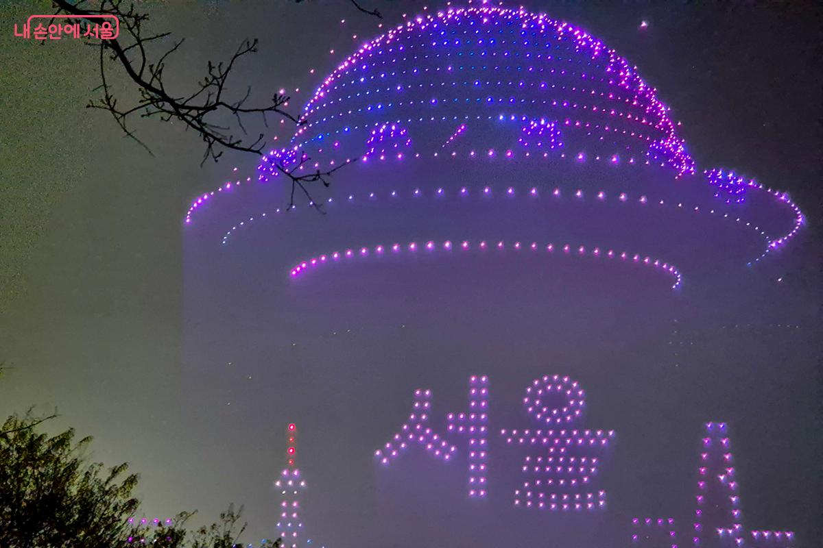 서울을 대표하는 남산타워 위를 날아오르는 우주선의 형상을 만들어내며 이날의 드론쇼를 시작한다.