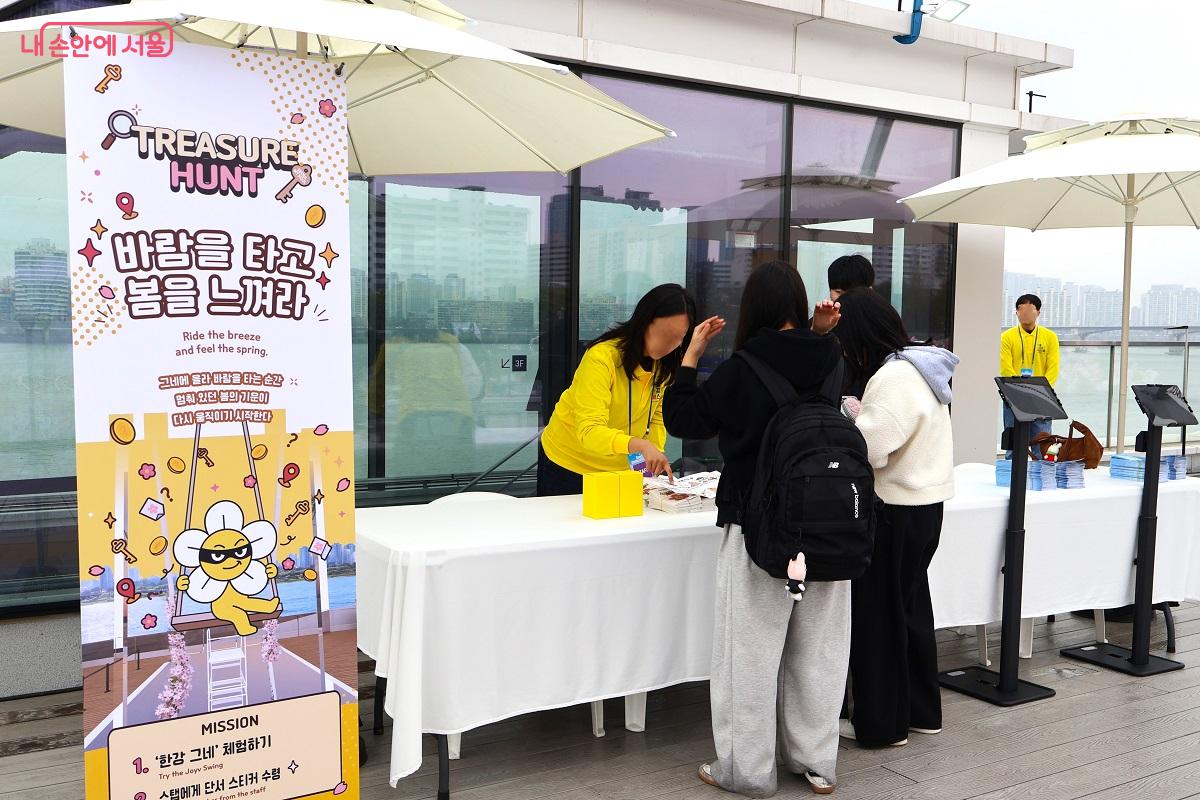 선착장 루프탑, '한강그네' 체험 후 트레저헌트 미션을 확인하는 체험객들 ⓒ이봉덕