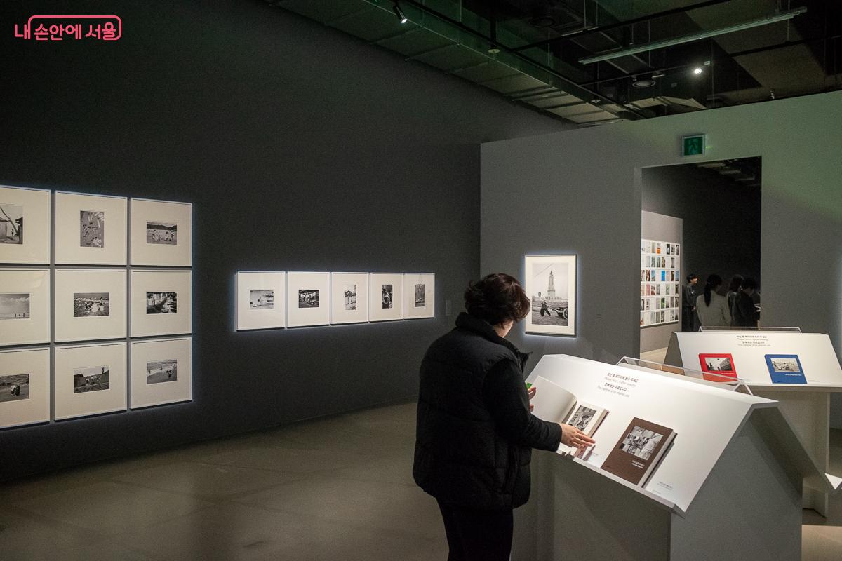 전시실에 마련된 사진집을 넘겨보며 작품에 몰입하는 관람객 &copy;이란