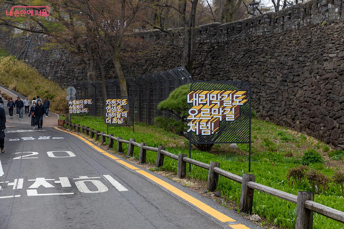 내리막길에 안내되어 있는 슬로건들 ⓒ문청야