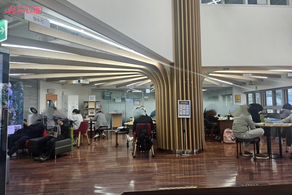 오픈 라운지의 모습으로, 10명 이상의 시민들이 각자 자유롭게 라운지에서 학습 및 휴식을 하는 모습이다.