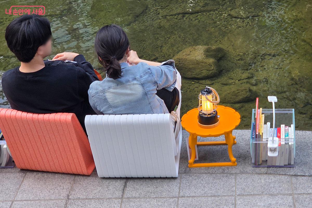 졸졸 흐르는 물소리를 배경 삼아 나란히 앉아 독서에 몰입한 시민들 &copy;이다현