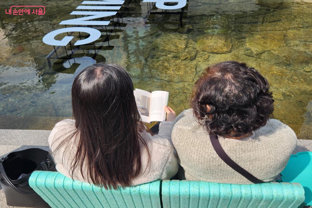 '책읽는 맑은냇가'를 방문한 모녀가 나란히 앉아서 책 한 권을 같이 읽는 모습이 아름답다. ⓒ윤혜숙