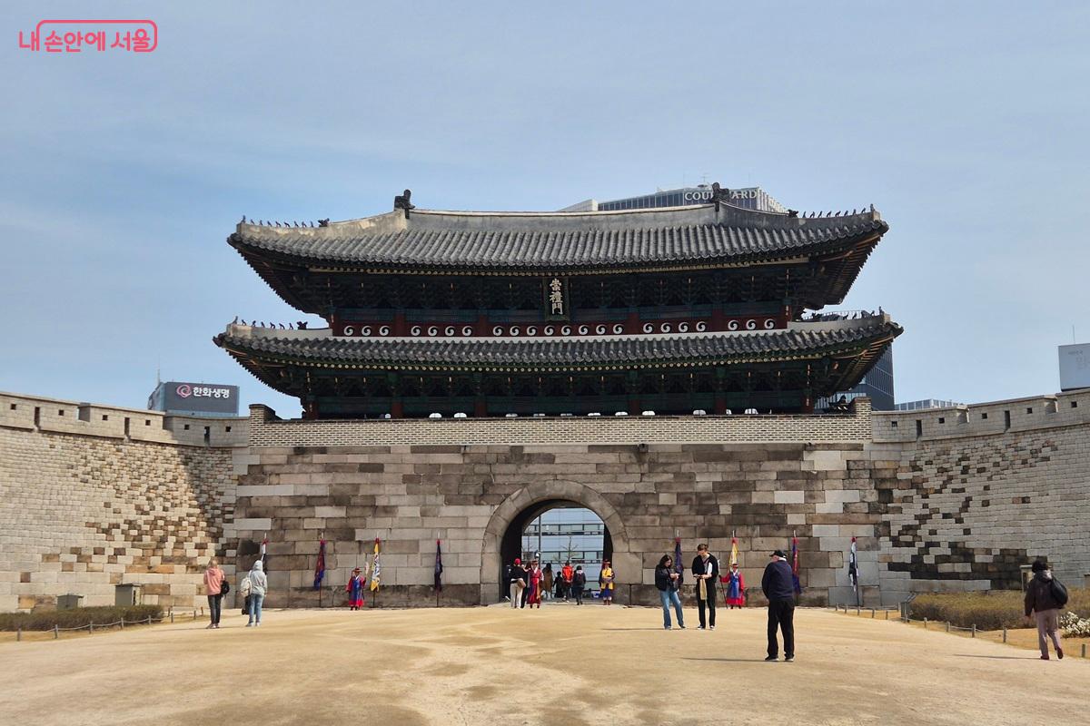 숭례문의 전경이다. 많은 관광객들이 구경하고 있고, 숭례문 앞에는 조선시대 복장을 한 사람이 문을 지키고 있다. &copy;마가은