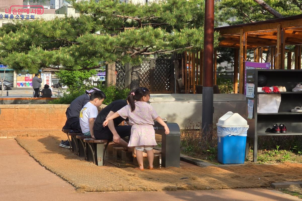 세족장에서 발을 씻는 어린이 가족 &copy;강사랑