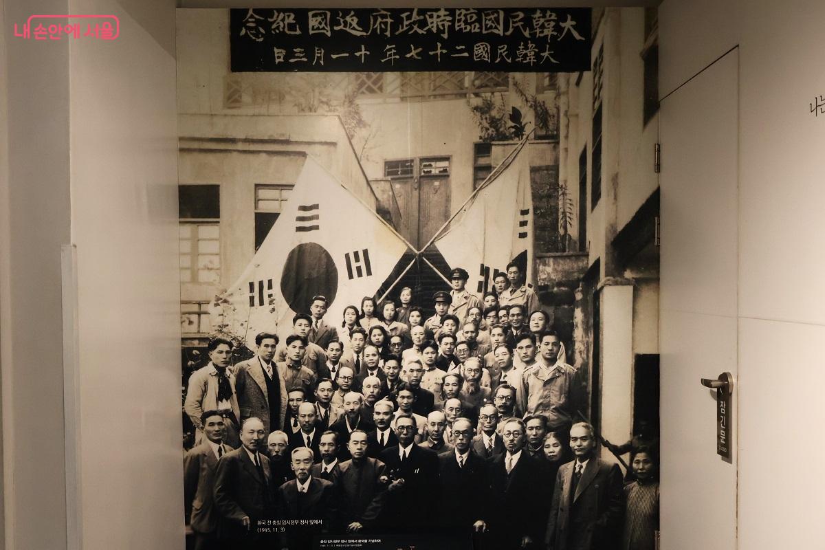 대한민국 임시정부 환국 기념 단체사진, 태극기 아래 1945년 11월 3일 촬영 &copy;김대진