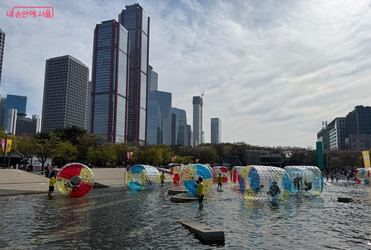여의도 빌딩숲을 배경으로 워터볼을 굴리는 시민들 ⓒ박소예