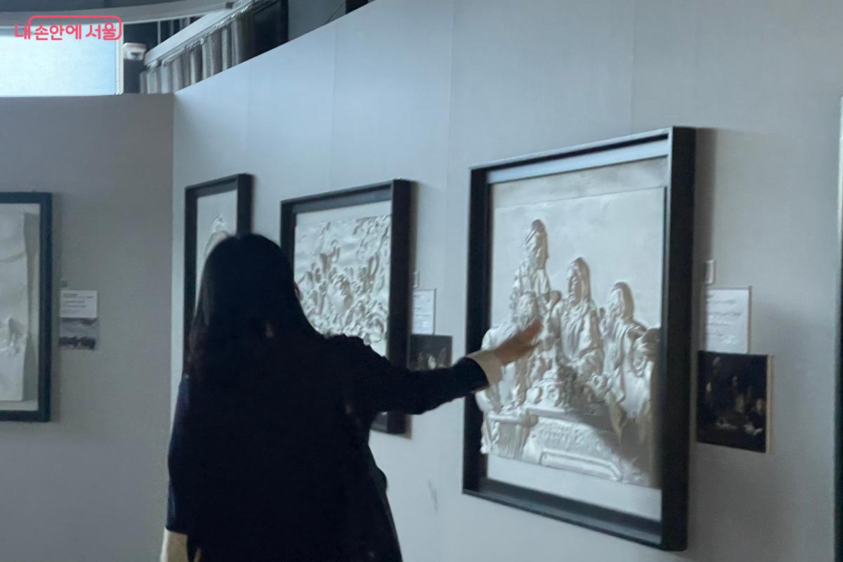 손끝으로 작품을 만지며 감상에 몰입 중인 관람객 ⓒ이정민