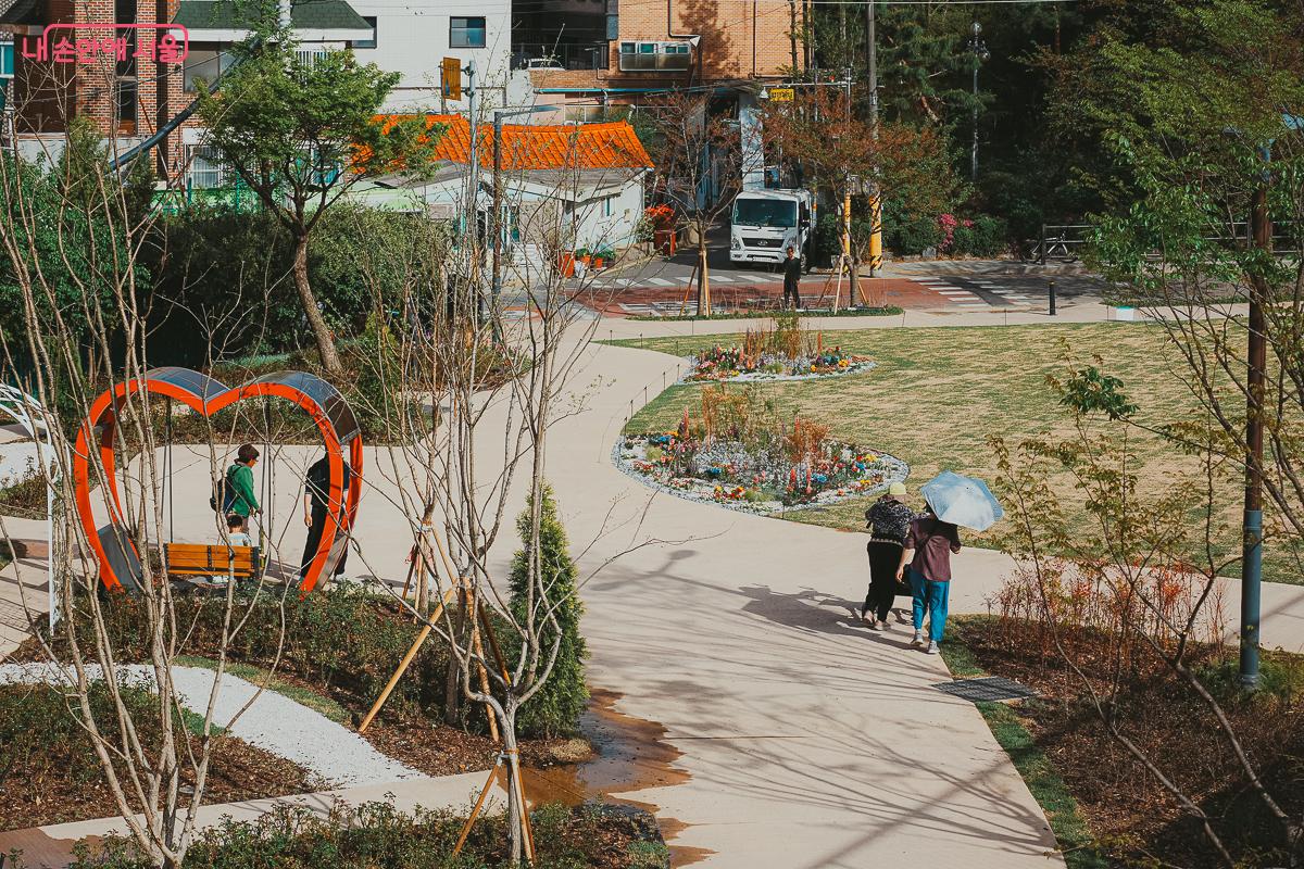 산책로를 따라 조성된 화단과 평탄한 길을 걷는 주민들의 여유로운 오후 &copy;김성무