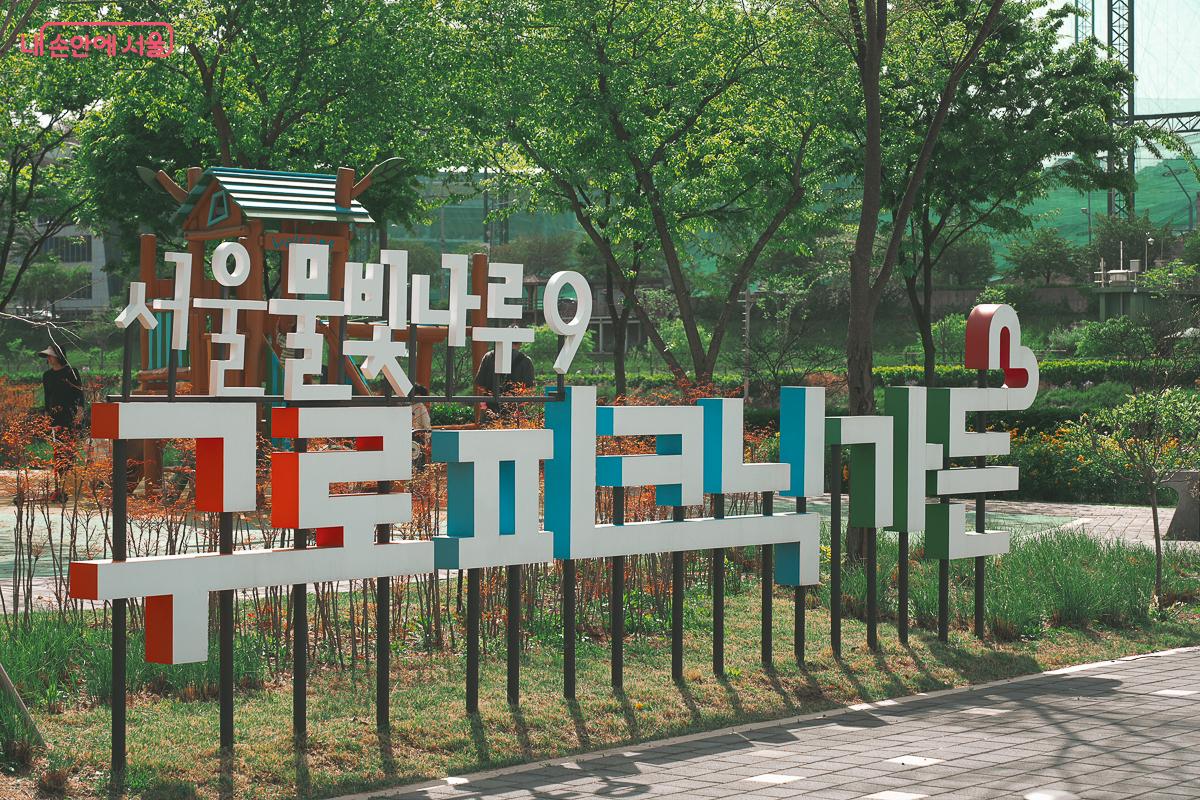 서울물빛나루9 구로피크닉가든이라고 적힌 알록달록한 입체 간판과 그 뒤로 나무로 만들어진 어린이 놀이터 미끄럼틀이 보인다. &copy;김성무
