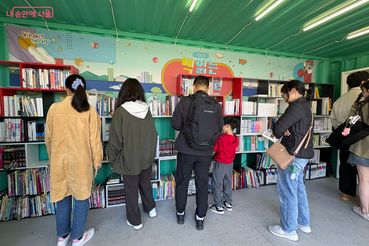 어른부터 아이까지 다양한 연령대의 시민들이 책을 고르고 있다.